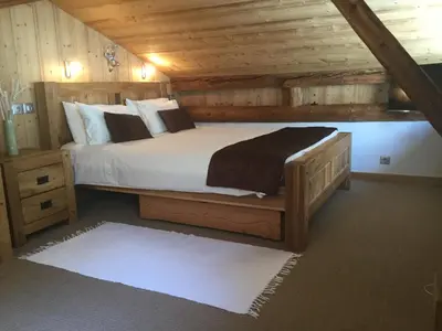 a bedroom with a large bed in a wooden cabin at La Grange De L'Aiguille in Chamonix-Mont-Blanc