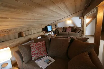 a living room with a couch and a tv at La Grange De L'Aiguille in Chamonix-Mont-Blanc