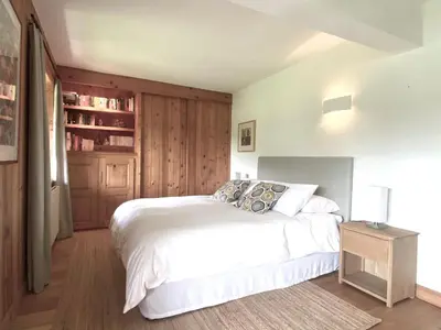 a bedroom with a white bed and a book shelf at Ferme Vauvray in Megève