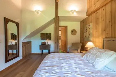 a bedroom with a large bed and a mirror at Ferme Vauvray in Megève