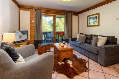 a living room with a couch and a table at Ginabelle 14 apartment - Chamonix All Year in Chamonix-Mont-Blanc