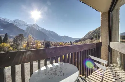 a balcony with a table and a view of mountains at Apartment Scott in Chamonix-Mont-Blanc