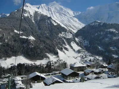 a ski resort with snow covered mountains in the background at Appartement St Nicolas in Saint-Gervais-les-Bains