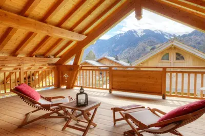 a room with two chairs and a table on a deck at Chambres d'hôtes de charme Douglas in Samoëns
