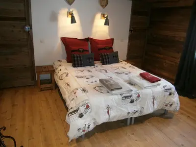 a bedroom with a large bed with a comforter at Chambres d'hôtes de charme Douglas in Samoëns