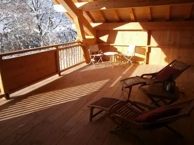 two chairs sitting on a porch of a cabin at Chambres d'hôtes de charme Douglas in Samoëns