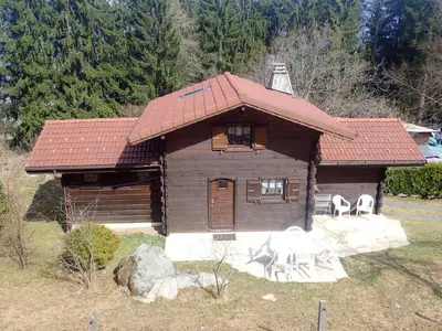 a small wooden house with white chairs in front of it at Chalet confortable à Saint-Gervais-les-Bains 60 m² vue montagne in Saint-Gervais-les-Bains