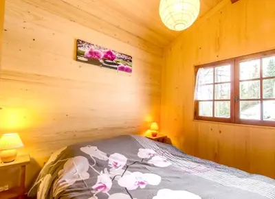 a bedroom with a bed in a wooden cabin at Chalet confortable à Saint-Gervais-les-Bains 60 m² vue montagne in Saint-Gervais-les-Bains