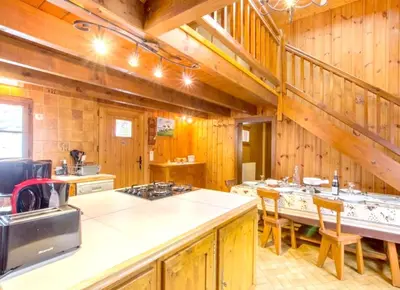 a kitchen with wooden walls and a table with chairs at Chalet confortable à Saint-Gervais-les-Bains 60 m² vue montagne in Saint-Gervais-les-Bains
