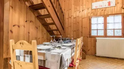 a dining room with a table in a wooden room at Chalet confortable à Saint-Gervais-les-Bains 60 m² vue montagne in Saint-Gervais-les-Bains