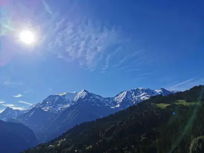 a view of a mountain range with the sun in the sky at Duo Des Alpages vue exceptionnelle sur le Mont Blc in Saint-Gervais-les-Bains