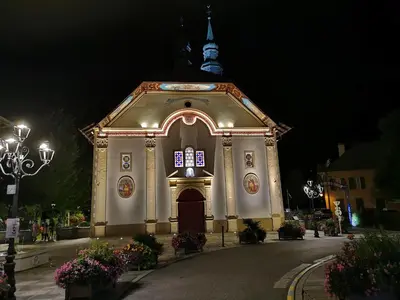 a church with a clock on the front of it at Duo Des Alpages vue exceptionnelle sur le Mont Blc in Saint-Gervais-les-Bains