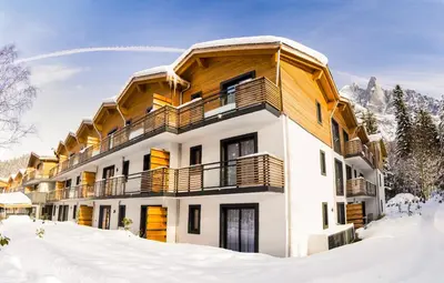 a building in the snow with snow covered ground at Résidence Odalys Isatis in Chamonix-Mont-Blanc