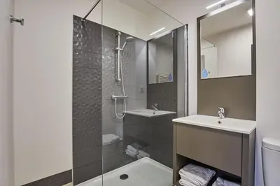 a bathroom with a shower and a sink and a toilet at Résidence Odalys Isatis in Chamonix-Mont-Blanc