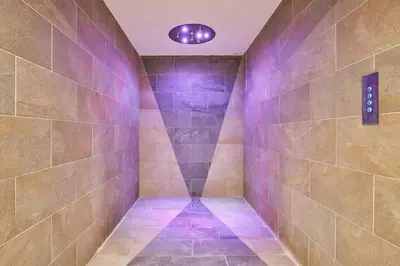 a walk in shower with purple lights on the wall at Résidence Odalys Isatis in Chamonix-Mont-Blanc