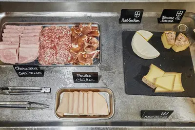 a table with different types of meats and cheese at Résidence Odalys Isatis in Chamonix-Mont-Blanc