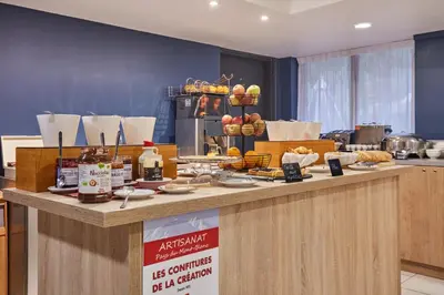 a restaurant with a counter with food on it at Résidence Odalys Isatis in Chamonix-Mont-Blanc