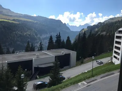 a building with a car parked in front of a road at SKI DORIS 310 Flaine Forêt in Flaine
