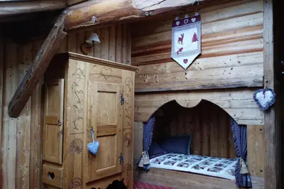 a log cabin with a bed in the middle at Chambre d'Hôtes La ferme d'en bas in Samoëns