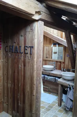 a bathroom with two sinks in a wooden building at Chambre d'Hôtes La ferme d'en bas in Samoëns