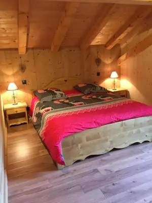 a bedroom with two beds in a log cabin at Chalet Lilalpes SPA in Samoëns