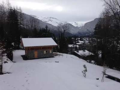 a cabin in the snow with mountains in the background at Chalet Lilalpes SPA in Samoëns