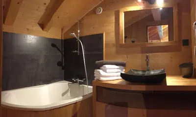 a bathroom with a sink and a bath tub at Chalet Lilalpes SPA in Samoëns