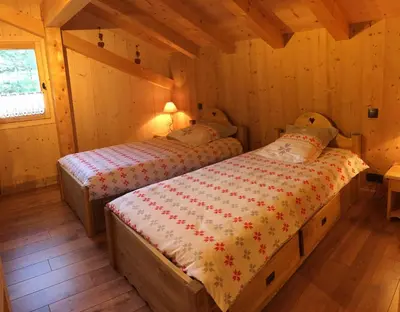 a bedroom with two beds in a cabin at Chalet Lilalpes SPA in Samoëns