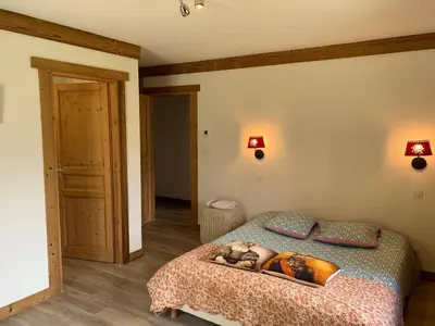 a woman laying on a bed in a bedroom at Le Chalet dans les Etoiles in Samoëns