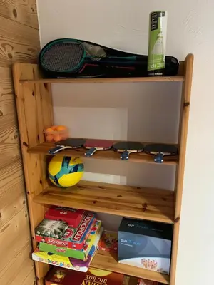 a wooden shelf with books and a tennis racket at Le Chalet dans les Etoiles in Samoëns