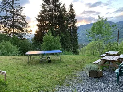 a picnic table and benches in a field at Le Chalet dans les Etoiles in Samoëns