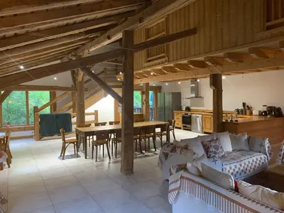 a large living room with a table and a kitchen at Le Chalet dans les Etoiles in Samoëns