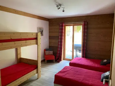 a bedroom with two bunk beds and a window at Le Chalet dans les Etoiles in Samoëns