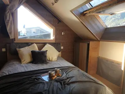 a bed in a room with a large window at Chamonix IRIS in Chamonix-Mont-Blanc