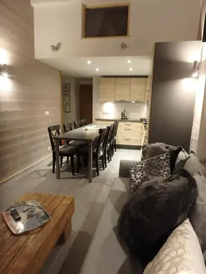 a living room with a couch and a table and a kitchen at Chamonix IRIS in Chamonix-Mont-Blanc
