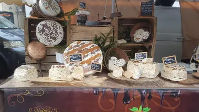 a display of cheeses on a table in a store at Duplex Les Périades 18 in Saint-Gervais-les-Bains