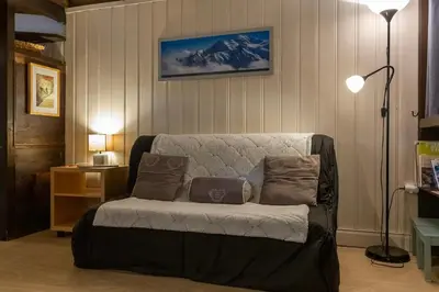 a living room with a couch with pillows on it at Duplex Chamonix Les Grands Montets in Chamonix-Mont-Blanc