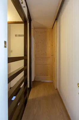 a hallway of a room with a door and wooden floors at Duplex Chamonix Les Grands Montets in Chamonix-Mont-Blanc