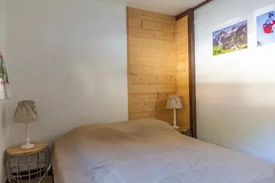 a small bedroom with a bed and two lamps at Duplex Chamonix Les Grands Montets in Chamonix-Mont-Blanc