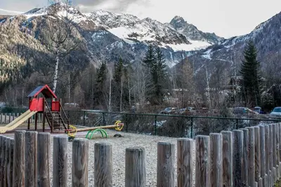 a playground with a slide in front of a mountain at Duplex Chamonix Les Grands Montets in Chamonix-Mont-Blanc