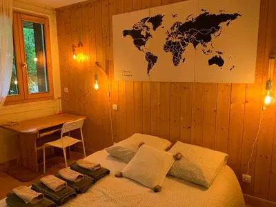a bedroom with a bed with a world map on the wall at Chamonix Studio Jardin in Chamonix-Mont-Blanc