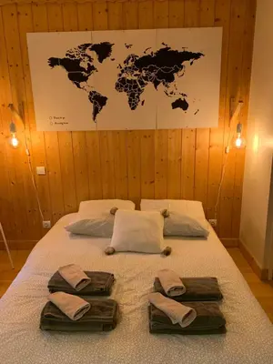 a bed with a map of the world on the wall at Chamonix Studio Jardin in Chamonix-Mont-Blanc