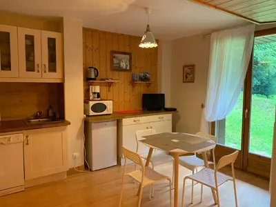 a kitchen with a table and chairs and a table and a table at Chamonix Studio Jardin in Chamonix-Mont-Blanc