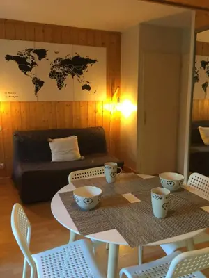 a room with a table and chairs and a room with a bed at Chamonix Studio Jardin in Chamonix-Mont-Blanc