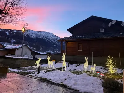 a group of giraffes in the snow in front of a house at Gite Michel Fagot in Les Houches