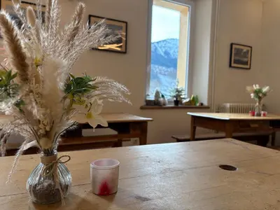 a large room with tables and a classroom with a screen at Gite Michel Fagot in Les Houches