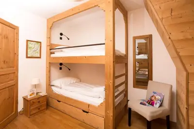 a room with a bunk bed with a chair and a mirror at Le Paradis 18 & 18b appts - Chamonix All Year in Chamonix-Mont-Blanc