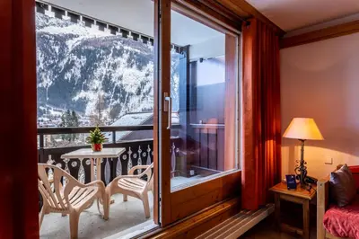 a room with a balcony with a view of the mountains at Les Balcons du Savoy in Chamonix-Mont-Blanc