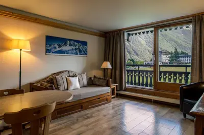 a living room with a couch and a large window at Les Balcons du Savoy in Chamonix-Mont-Blanc