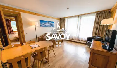 a living room with a wooden table and a dining room sidx sidx sidx at Les Balcons du Savoy in Chamonix-Mont-Blanc
